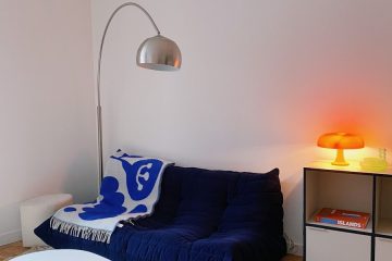 a living room with a couch and a lamp