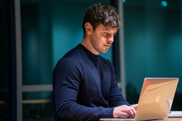man in black long sleeve shirt using macbook