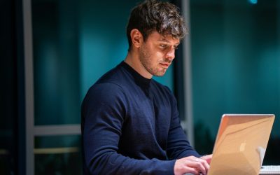 man in black long sleeve shirt using macbook